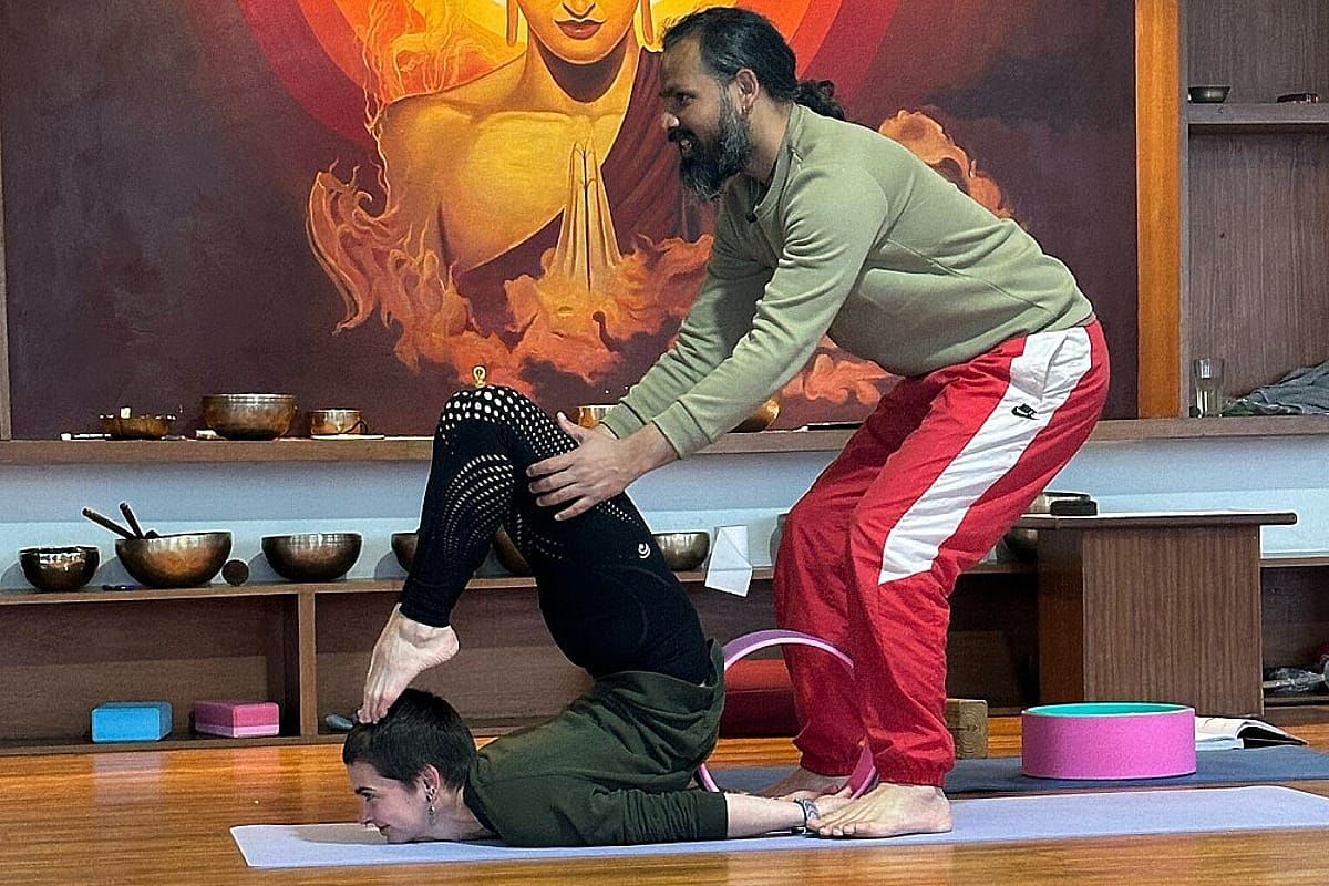 Instructor adjusting a student during a retreat yoga class