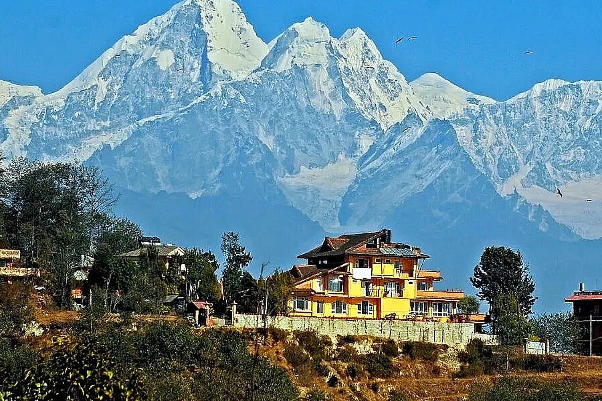 Village on a Kathmandu yoga retreat hike with snow peaks behind
